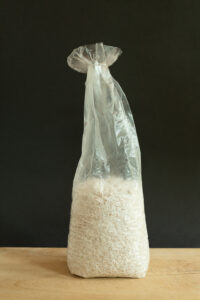A bag of rice on a wooden table.