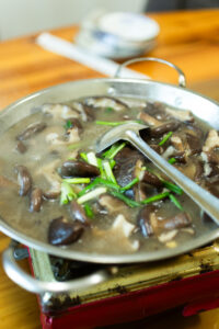 A pan of soup with mushrooms in it.